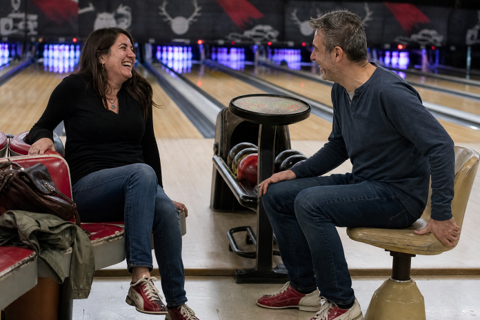First date at a bowling alley Two people in their forties laughing at a gutter ball on a first date at a bowling alley