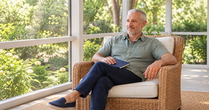 A quiet moment of inner reflection A silver-haired bearded man rests in a porch armchair with a closed blue notebook on his lap.