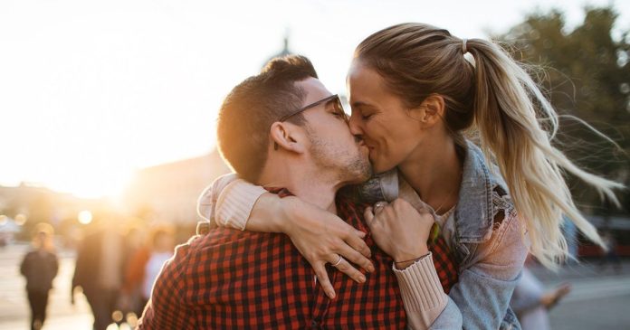 Love reading relationship reflection A couple embracing and kissing outdoors in warm sunlight.